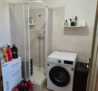 Bathroom in a family house with a sink, shower, and washing machine.