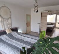 Bedroom in a family house with a double bed, wardrobe, and decorations in neutral tones.