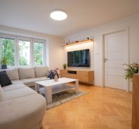 Living room in a 3-room apartment with a large sofa and a floor with a wooden decor.