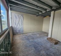 The interior of a family house with unfinished flooring and drywall walls.