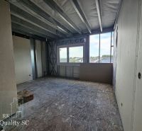 Construction site inside a family house with a view through a large window.