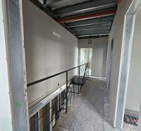 Construction work inside a family house with a staircase and incomplete walls.