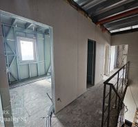 The interior of a family house with metal frames and a concrete floor.