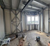 Interior of a family house under construction with a metal structure and a window with a view.