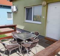 Garden terrace of a one-room apartment in Boldog with seating by the green house.