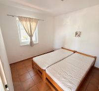Bedroom in a one-room apartment with a double bed and tiles.