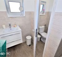 A bathroom in a cabin with a sink, toilet, and a floor with a wood decor.