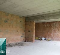 Brick construction in the interior of a family house with a concrete ceiling and cleaning tools.