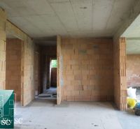 The interior of a family house under construction with exposed brick walls.