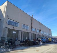 Warehouses and halls on Staviteľská Street in Bratislava III with trucks and materials.