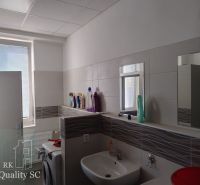 Bathroom with a sink, washing machine, and cleaning products in storage rooms and halls.