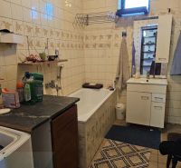 Bathroom with a bathtub and cabinets in a family house.