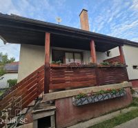 A family house in the village of Tureň on Tureň Street with a wooden terrace and railing.