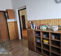 A kitchen in a family house with a wooden decor floor and storage shelves.