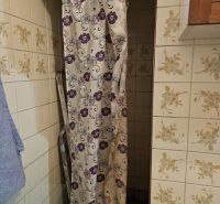 Bathroom in a family house with a shower and floral tiles.