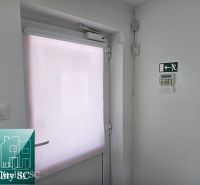 White doors with a shutter and an emergency exit in commercial premises.