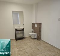 Bathroom with tiles, sink, and toilet in commercial premises.