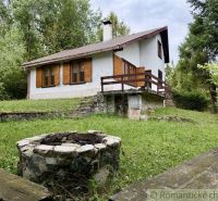 A cottage in Košická Belá with a fireplace in the middle of a green lawn.