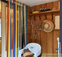 The interior of a cabin with colorful stripes, hats, and rackets on the wooden wall.