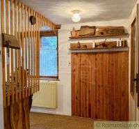 Interior of a cabin with wooden decoration and a shelf with traditional elements.