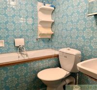 A bathroom with retro blue tiles, a sink, a bathtub, and a toilet in a cabin.