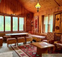 The interior of the cabin with wooden floor decor, colorful rugs, and wooden furniture.