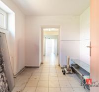 A corridor with white walls and tiles in commercial premises.