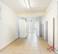 Hallway in commercial premises with white walls and ceramic flooring.