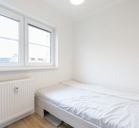 A bright bedroom with a bed and a window in a 2-room apartment.