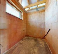 An unfinished room with brick walls in a family house, ready for further renovation.