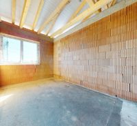 An unfinished room in a house under construction with a large window.
