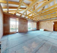Unfinished room with brick walls in a family house with a wooden truss.