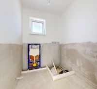Unfinished bathroom in a family house with a window and installation for a toilet.