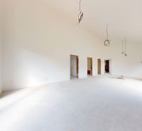 A spacious bright room without furniture in a family house with large windows.