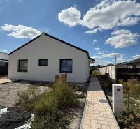 A family house on Karasova Street in Senec with a landscaped outdoor area and a blue sky.