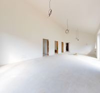 A spacious room with large windows in a family house, waiting to be finished.