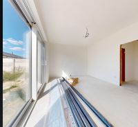 Interior in a family house with a large window and construction materials on the floor.