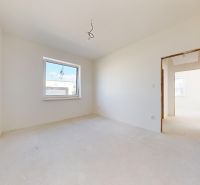 Interior of an empty room in a family house with white walls and a large window.
