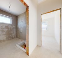 Rooms under construction in a family house with unfinished plaster and a bright interior.