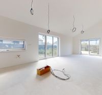 A spacious interior of a family house with large windows, waiting to be completed.