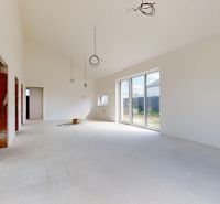 A family house with a high ceiling, large windows, and a concrete floor prepared for completion.