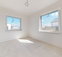 A spacious bright room in a family house with large windows and a concrete floor.