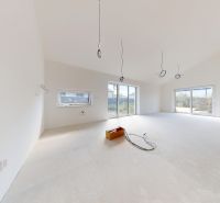 A spacious room in a family house with large windows and white walls.