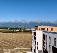 View of the mountains and a building from Suchoňova Street in Poprad, ideal for a 4-room apartment.