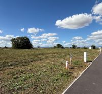 A vacant plot next to a family house on Bernolákova Street in Nová Dedinka with an asphalt road.
