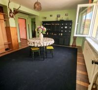 Living room in a family house with flowers on the table and an open window.