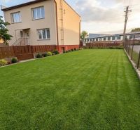 A family house in Záhorská Ves with a manicured lawn and simple fencing.