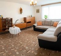 Living room in a family house with a comfortable sofa set and wooden furniture.