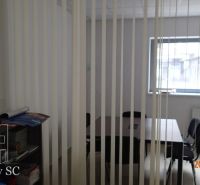 Meeting room with a window and vertical blinds in the office, table and chairs.