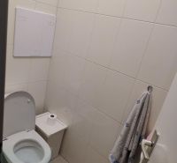 Toilet with wall tiles, toilet, towel, and bin in Offices.